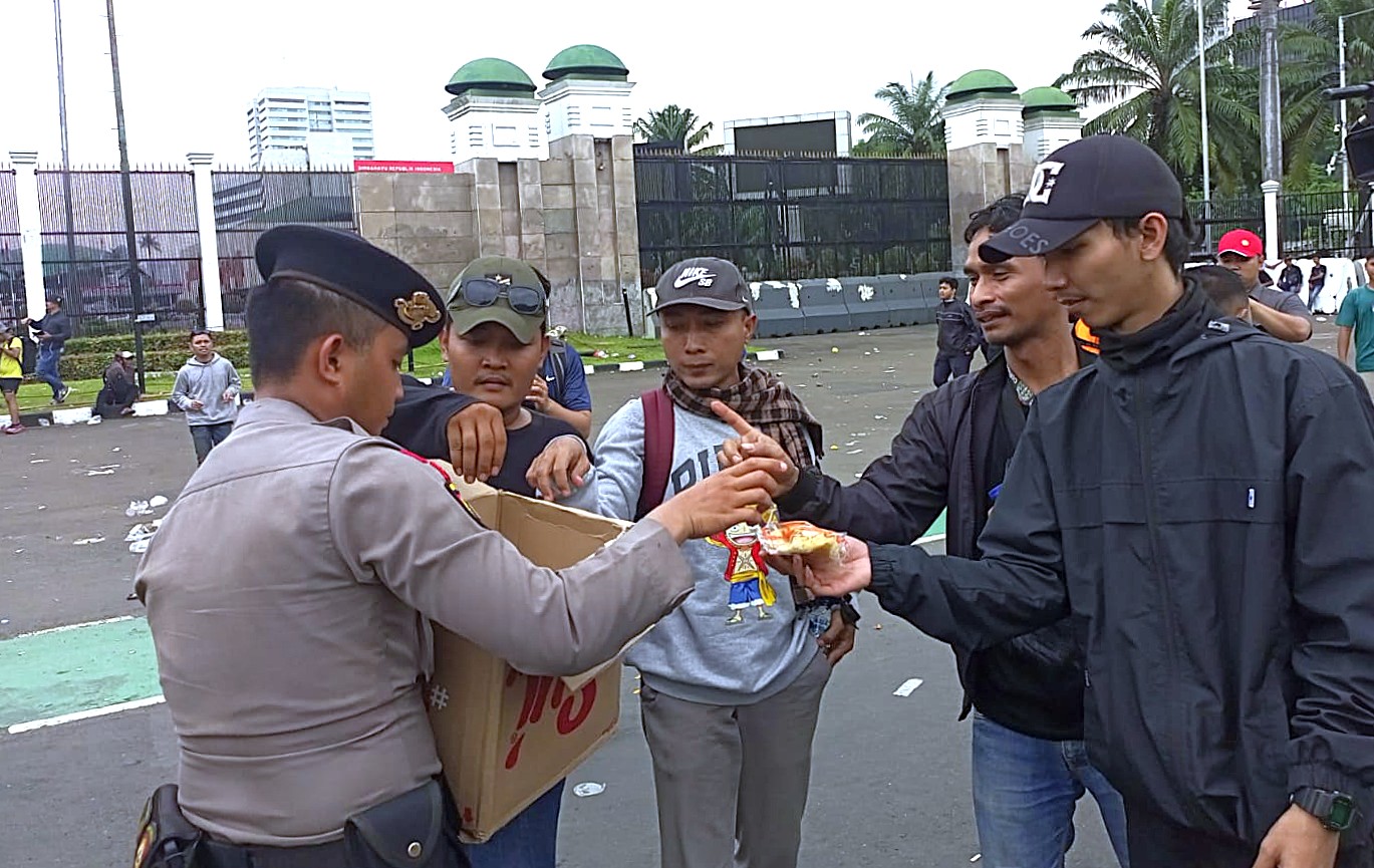 Aksi Simpatik, Polisi Bagikan Air Mineral dan Roti kepada Buruh di Depan DPR/MPR